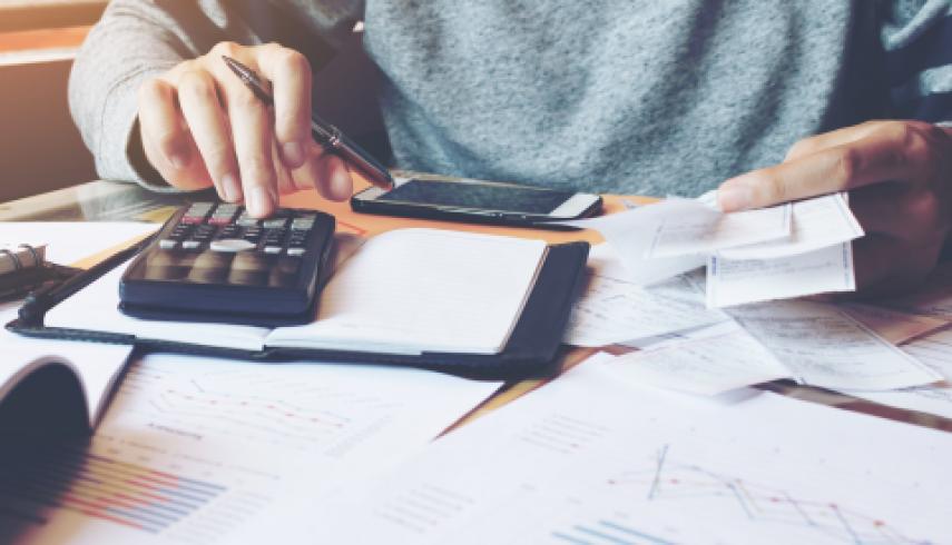 man using calculator to pay taxes