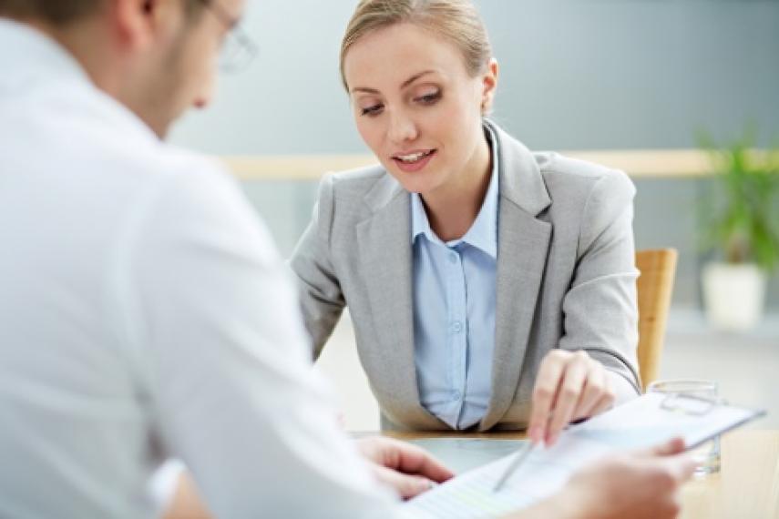 women showing clipboard to man